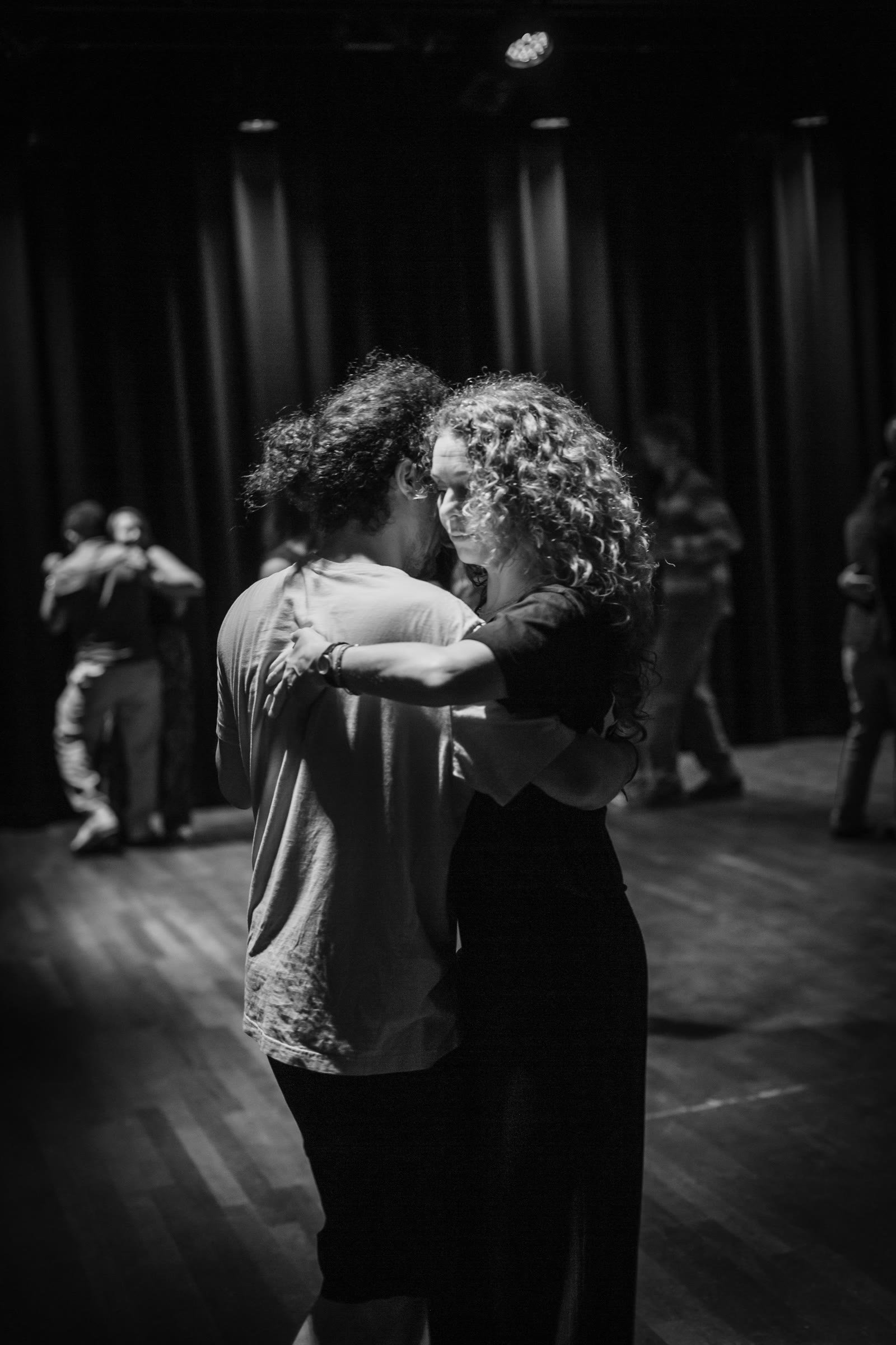 A couple dancing forró in a close embrace, in black and white